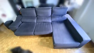 Resultado premium tras limpieza de tapicería en sofá chaiselongue oscuro en La Moraleja, Madrid