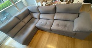 Gran sofá rinconera gris apagado por el polvo antes de la limpieza técnica en Aravaca