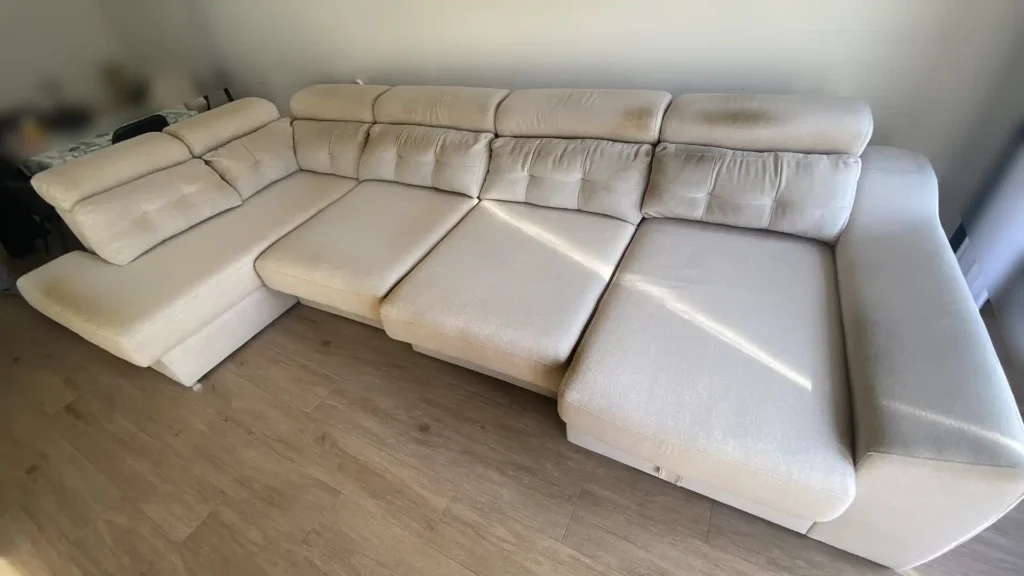 Gran sofá rinconera beige con fuertes manchas oscuras en reposacabezas antes de su limpieza en Arroyomolinos
