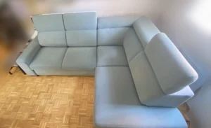 Sofá azul claro totalmente renovado y sin manchas oscuras tras la limpieza a domicilio en Sanchinarro