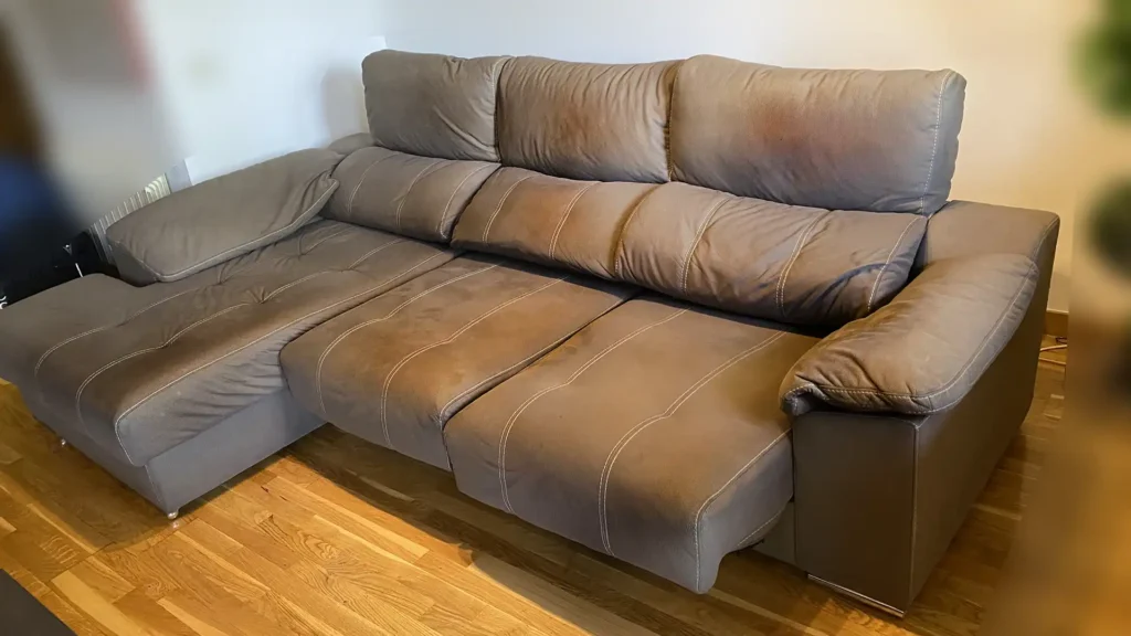Sofá chaiselongue tono topo con asientos extraíbles y costuras oscurecidas antes de limpiar en zona norte de Pozuelo