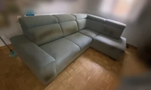 Sofá rinconera azul claro con severas manchas oscuras en reposacabezas antes de limpiar en Sanchinarro