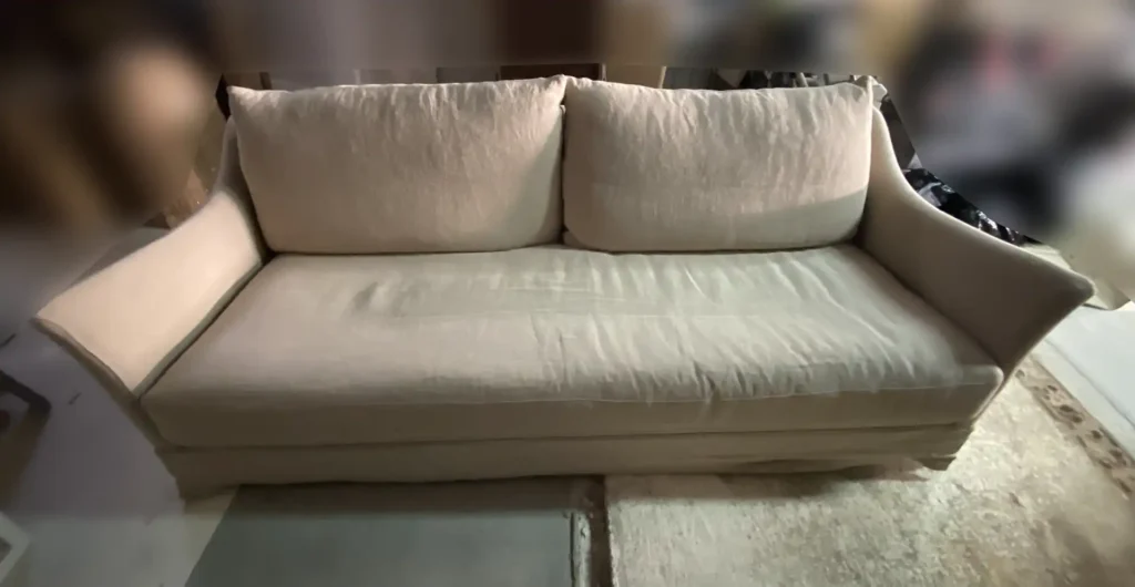 Sofá de lino natural con pérdida de color y polvo acumulado en los asientos antes del lavado