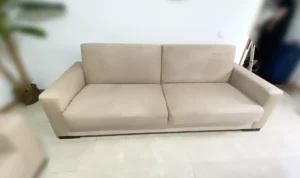 Sofá beige de microfibra completamente limpio, peinado y sin surcos oscuros tras el lavado a domicilio