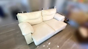 Sofá de dos plazas color crema con tela de relieve muy limpio