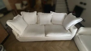 Estado inicial del sofá en Barrio de Salamanca: se observan sombras grisáceas en las zonas de asiento y manchas localizadas sobre el algodón blanco.